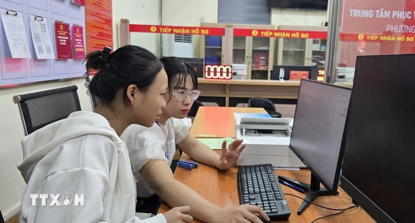 A civil servant of Phu Lien ward, Hai Phong city, gives guidance on how to submit marriage registration dossiers via the National Public Service Portal. (Photo: VNA)