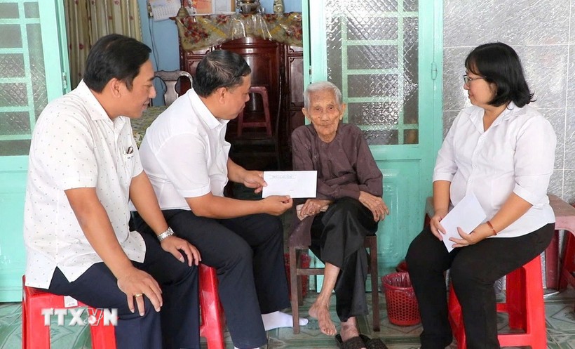 Leaders of the Party Committee, People's Council, People's Committee, and Vietnam Fatherland Front Committee of Phu Loi ward, Ho Chi Minh City, present gift from the Party and State to a social assistance recipient at her home on the occasion of the 14th National Party Congress and the 2026 Lunar New Year. (Photo: VNA)