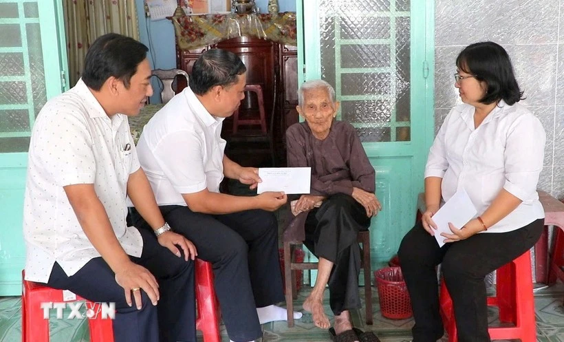 Leaders of the Party Committee, People's Council, People's Committee, and Vietnam Fatherland Front Committee of Phu Loi ward, Ho Chi Minh City, present gift from the Party and State to a social assistance recipient at her home on the occasion of the 14th National Party Congress and the 2026 Lunar New Year. (Photo: VNA)