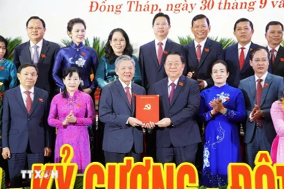 Politburo member, Secretary of the Party Central Committee, and Head of the Commission for Information, Education, and Mass Mobilisation Nguyen Trong Nghia (third, right) presents a decision to the new Secretary of the Dong Thap provincial Party Committee Ngo Chi Cuong. (Photo: VNA) 