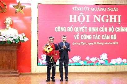 Le Minh Hung (R), Politburo member, Secretary of the Party Central Committee and Chairman of its Organisation Commission, hands over the appointment decision and congratulation flowers to Ho Van Nien, the new Secretary of the Quang Ngai Party Committee (Photo: VNA)