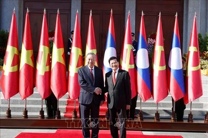 General Secretary of the Lao People’s Revolutionary Party (LPRP) Central Committee and President of Laos Thongloun Sisoulith (Right) welcomes General Secretary of the Communist Party of Vietnam (CPV) Central Committee To Lam during his state visit to Laos. (Photo: VNA)