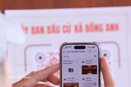 A voter scans a QR code with their smartphones to quickly check information related to their voting rights. (Photo: VNA)