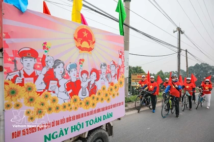 A communication team of O Dien commune in Hanoi cycle to support the general election. (Photo: VNA)
