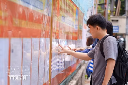 Students at the University of Technology and Education - The University of Danang study the list of candidates posted at the university. (Photo: VNA)