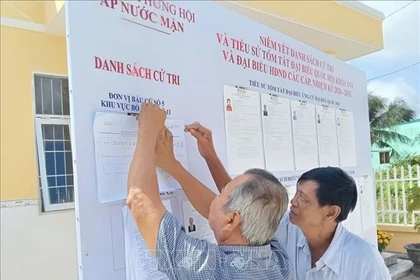 Voters study information of candidates to the 16th National Assembly and People’s Councils at all levels in the 2026-2031 tenure. (Photo published by VNA)