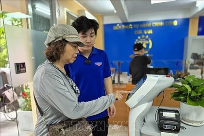 Citizens use an AI-powered robot to handle administrative procedures in Cua Nam ward in Hanoi. (Photo: VNA)