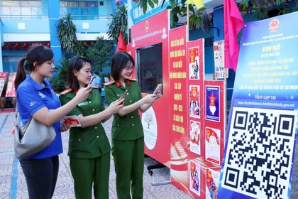 Young voters in Ho Chi Minh City scan an QR code to participate in an online quiz about the Election Law. (Photo: VNA)
