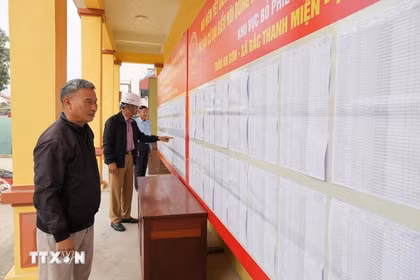 Voters review the lists of candidates and their brief biographies. (Photo: VNA) 