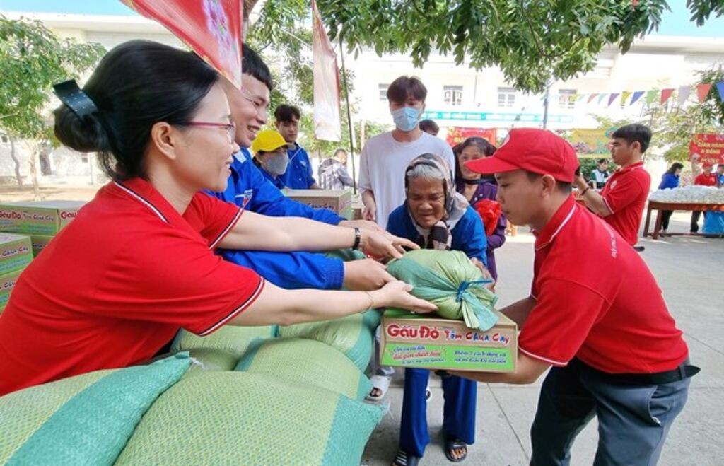 Staff members of the Ninh Thuan provincial Red Cross Society assist elderly people with difficult circumstances in transporting goods at a humanitarian market fair. (Photo: VNA)
