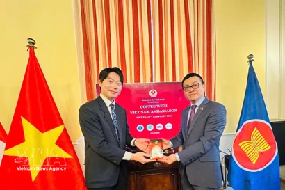 Vietnam’s Ambassador to Austria Vu Le Thai Hoang (R) presents Vietnamese coffee to an international student. (Photo: VNA)