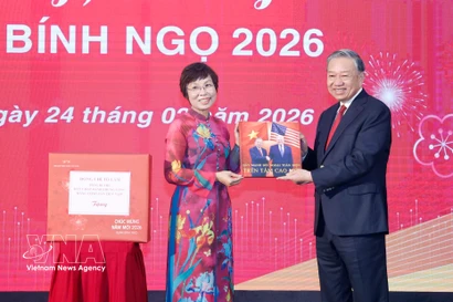VNA General Director Vu Viet Trang (L) presents a photo book to Party General Secretary To Lam. (Photo: VNA)