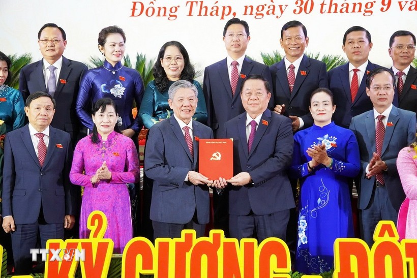 Politburo member, Secretary of the Party Central Committee, and Head of the Commission for Information, Education, and Mass Mobilisation Nguyen Trong Nghia (third, right) presents a decision to the new Secretary of the Dong Thap provincial Party Committee Ngo Chi Cuong. (Photo: VNA) 
