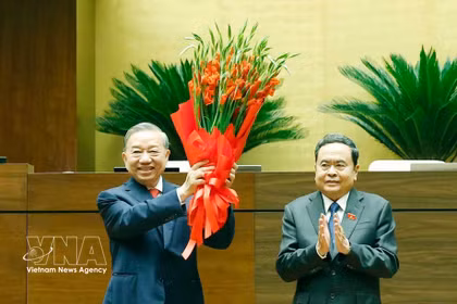National Assembly Chairman Tran Thanh Man (R), on behalf of the Party and State leaders and deputies of the 16th National Assembly, presents flowers to congratulate Party General Secretary and State President To Lam. (Photo: VNA) 