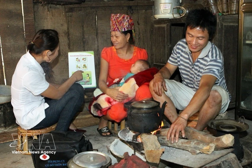 A medical worker gives guidance to a mother on how to care for a newborn in Ta Ca commune, Nghe An province. (Photo: VNA)