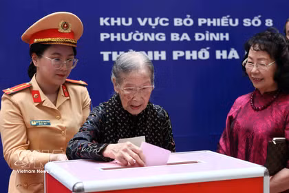 101-year-old voter Doan Thi Thuan (centre) casts her ballot at the polling station at Phan Chu Trinh primary school, Ba Dinh ward, Hanoi. (Photo: VNA)
