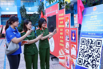 Young voters in Ho Chi Minh City scan an QR code to participate in an online quiz about the Election Law. (Photo: VNA)