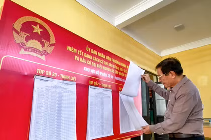 A voter carefully learns about candidates before the Election Day. (Photo: VNA)