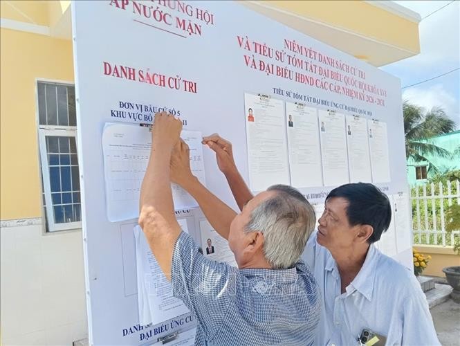 Voters study information of candidates to the 16th National Assembly and People’s Councils at all levels in the 2026-2031 tenure. (Photo published by VNA)