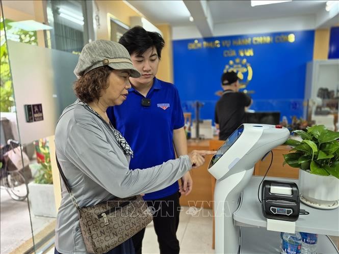Citizens use an AI-powered robot to handle administrative procedures in Cua Nam ward in Hanoi. (Photo: VNA)