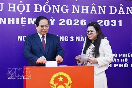 Prime Minister Pham Minh Chinh and his spouse cast ballots at Polling Station No. 21 in Tay Ho ward, Hanoi, on March 15 morning. (Photo: VNA)