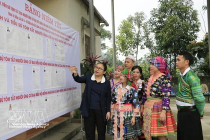 The head of Polling Team No. 5 in Quy Mong commune, Lao Cai province, introduces the lists of candidates to local residents. (Photo: VNA)