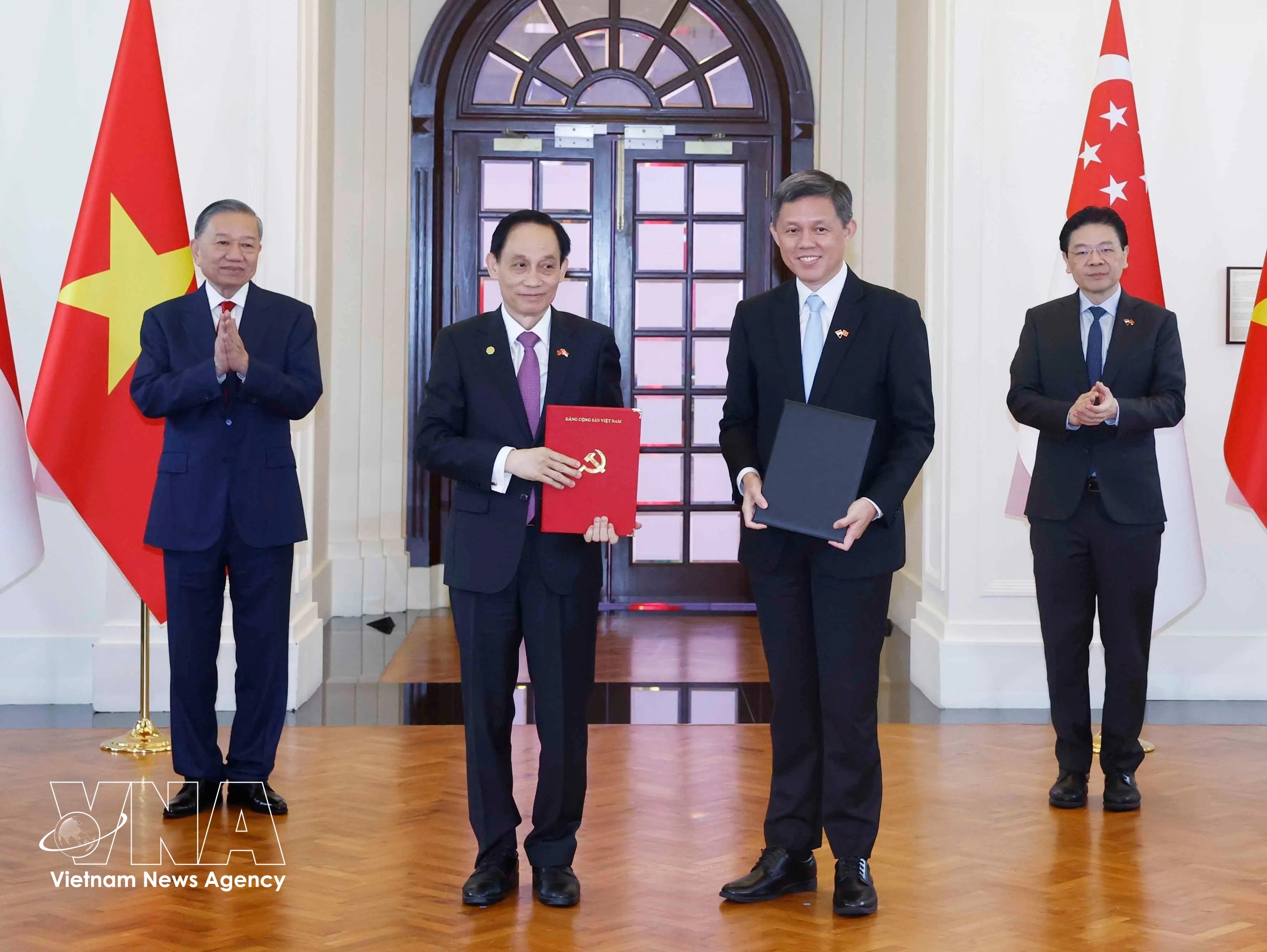 General Secretary of the Communist Party of Vietnam and President of Vietnam To Lam (first, left) and Prime Minister of Singapore Lawrence Wong (first, right) witness the exchange of cooperation documents on May 29. (Photo: VNA)